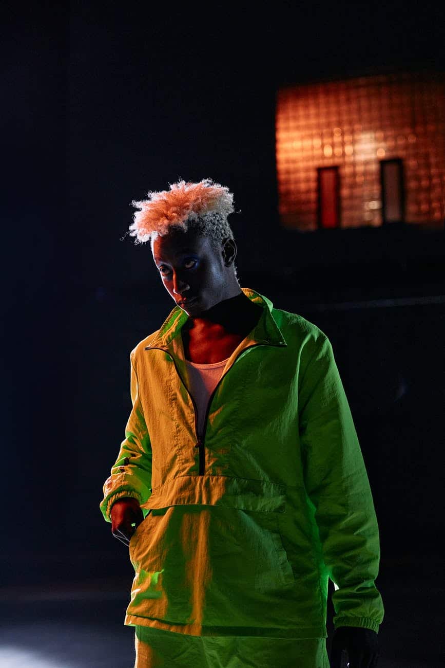 a man in neon green jacket standing while looking afar