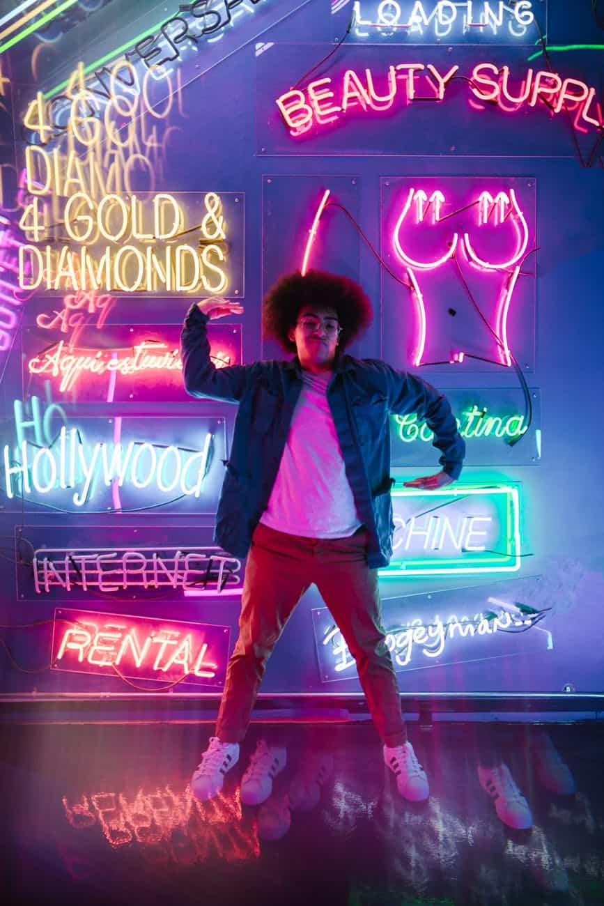 man dancing with neon lights and signs on background