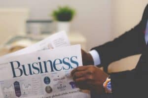 An entrepreneur holding white and blue business paper preparing for a business meeting.