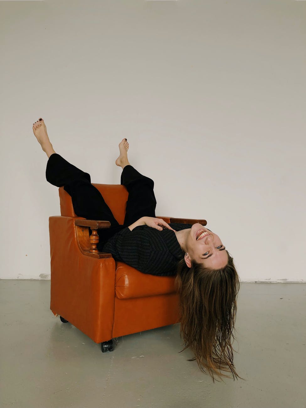 woman in sitting upside down in armchair