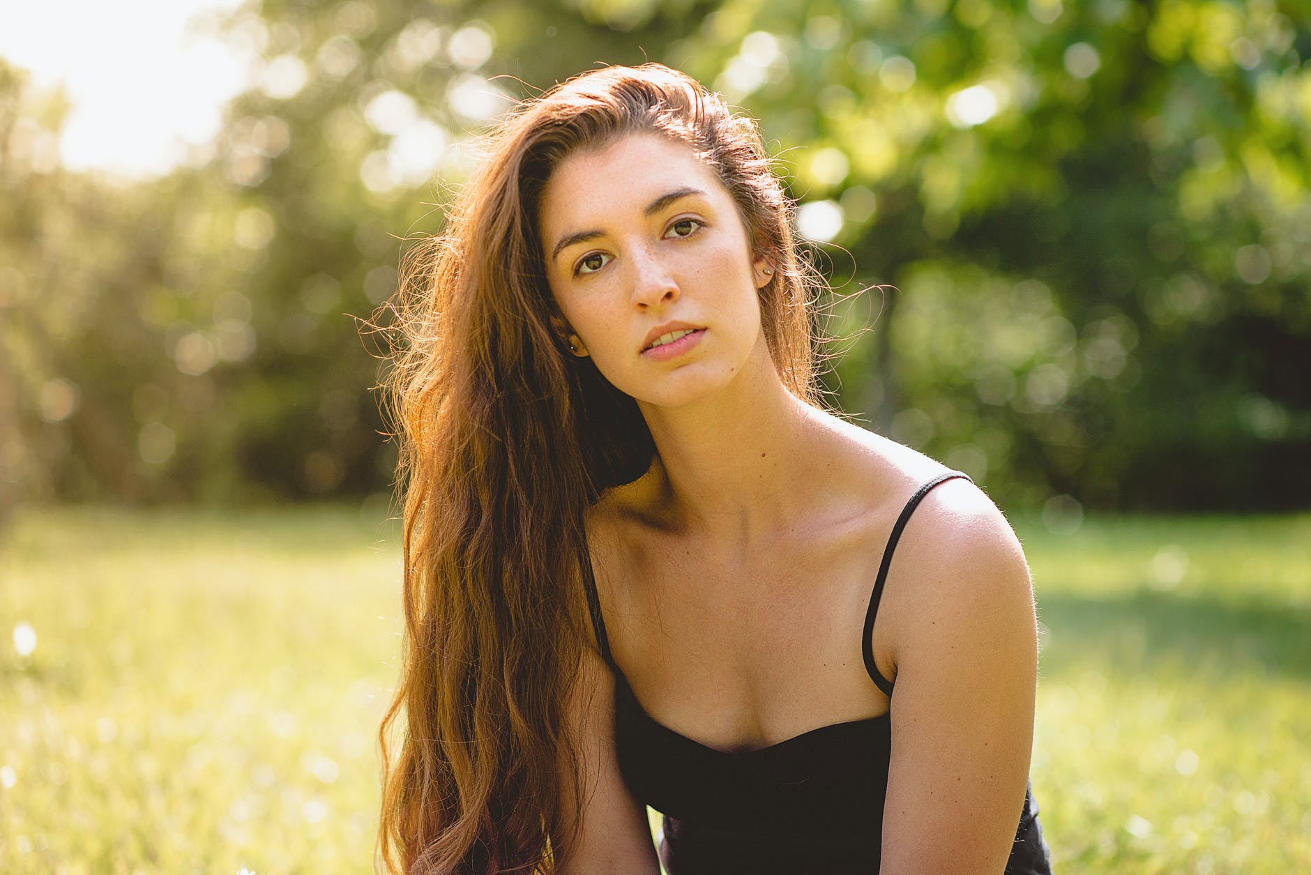 woman in black spaghetti strap top near trees