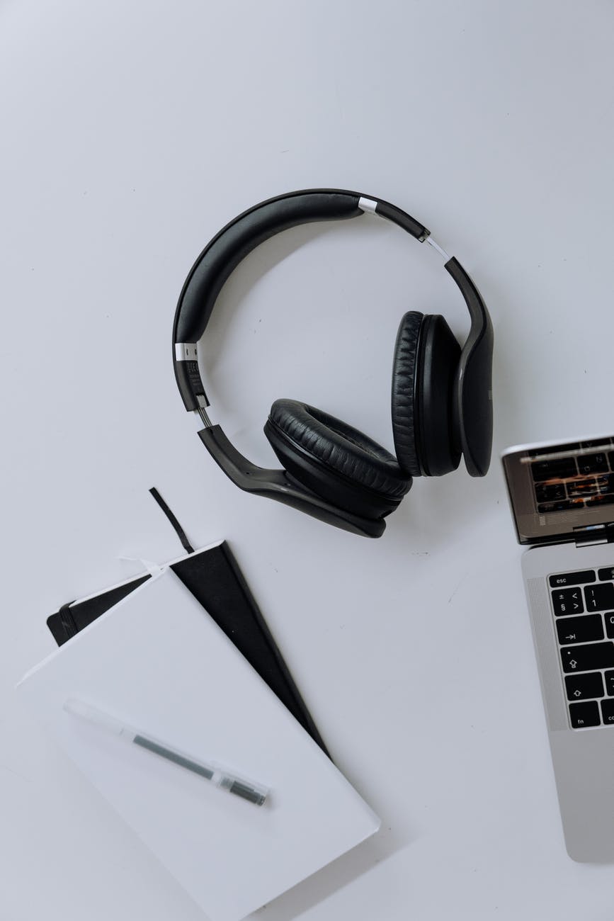 black and silver headphones beside macbook pro