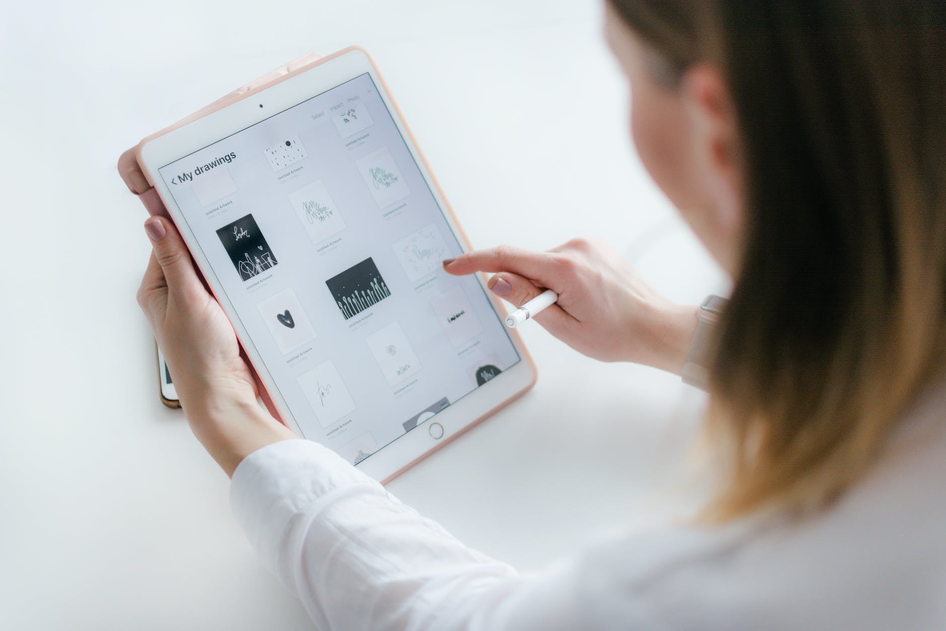 woman sitting beside table while using ipad